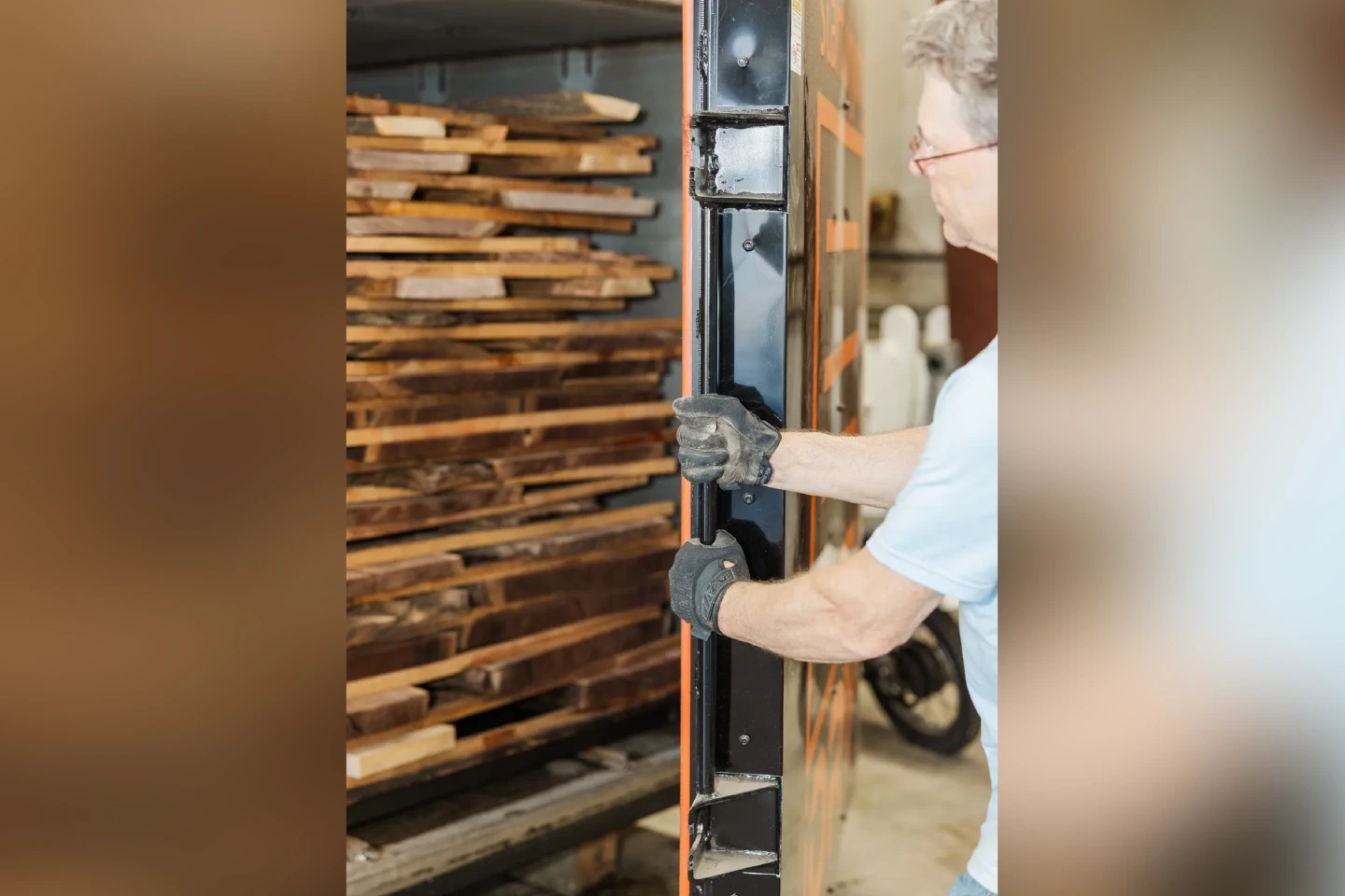 Person handling wooden planks stacked vertically.