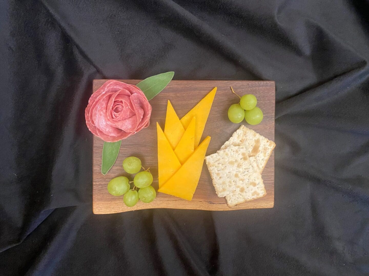 Cheese, crackers, grapes, and salami rose platter.