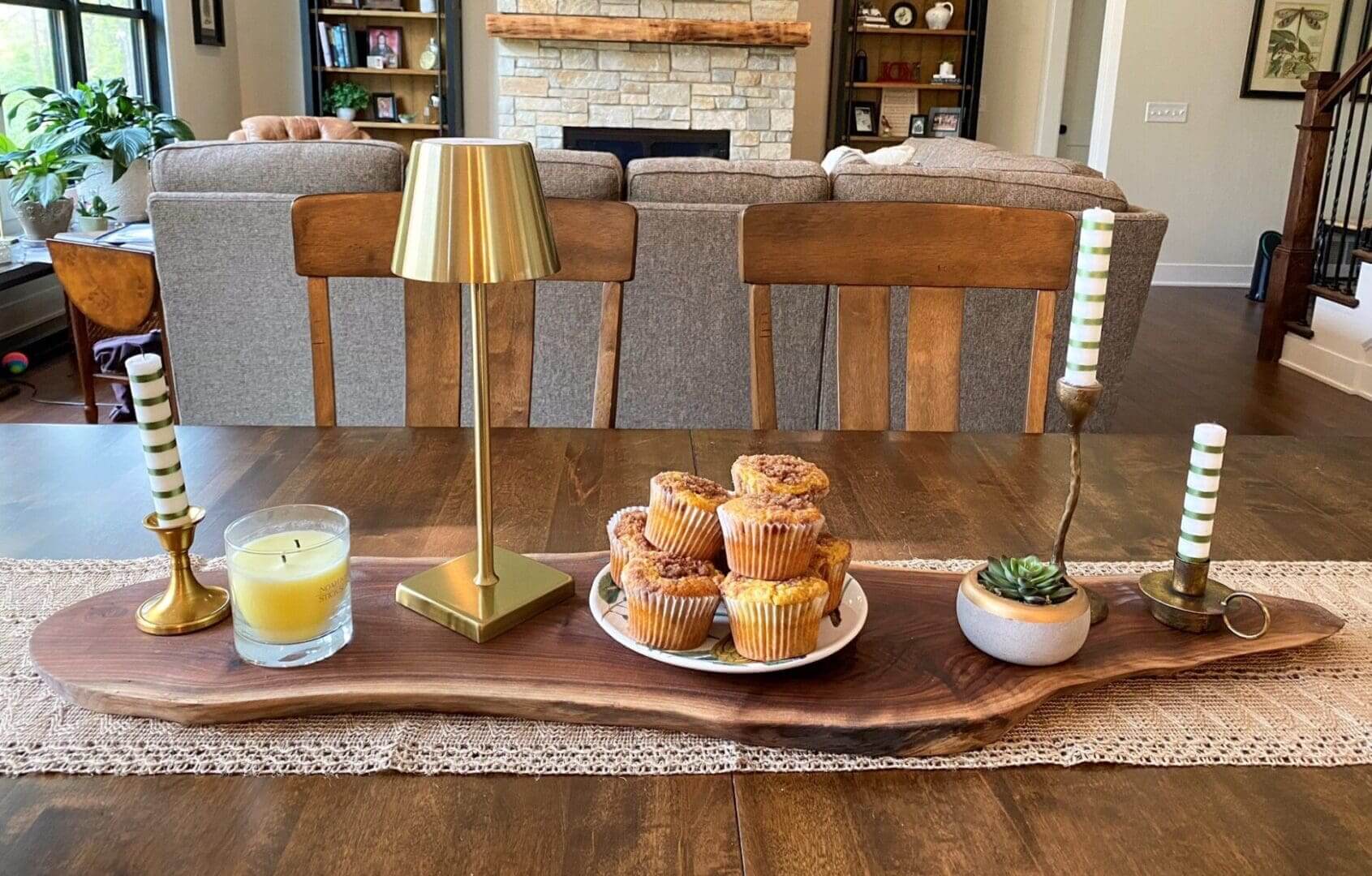 Dining table with muffins and decorative items.